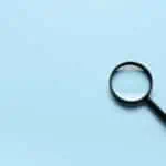 a magnifying glass on a sky blue background