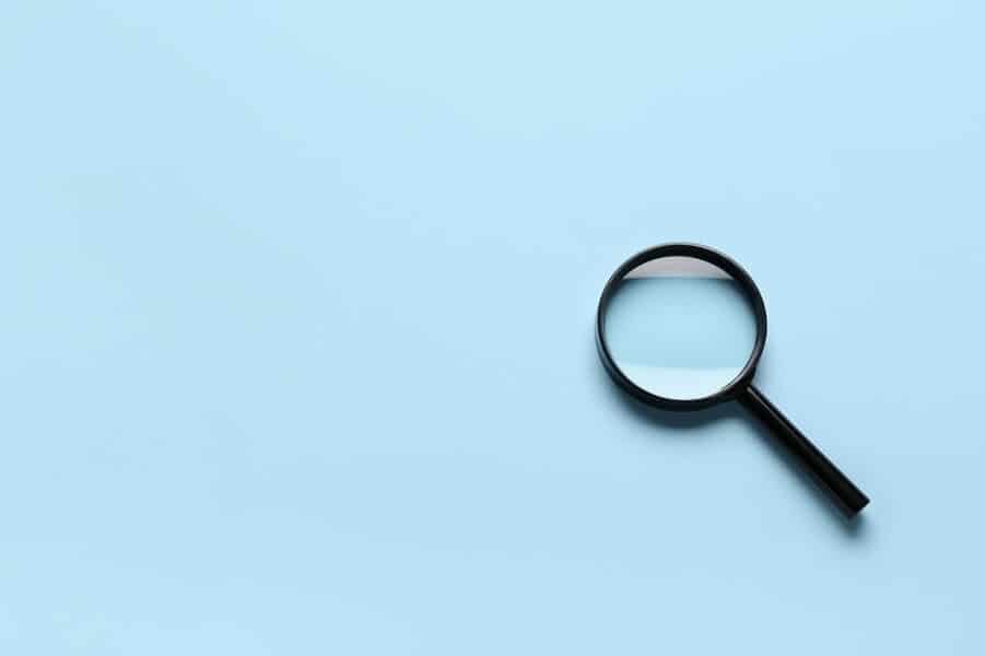 a magnifying glass on a sky blue background
